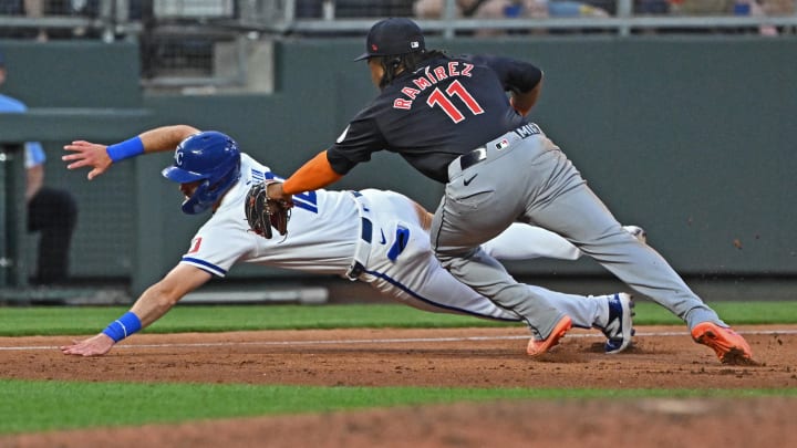 Jun 27, 2024; Kansas City, Missouri, USA; Kansas City Royals third baseman Nick Loftin (12) dives for third base against Cleveland Guardians third baseman Jose Ramirez (11) in the fifth inning at Kauffman Stadium. Mandatory Credit: Peter Aiken-USA TODAY Sports