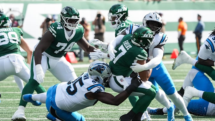 Oct 19, 2025; East Rutherford, New Jersey, USA; New York Jets quarterback Justin Fields (7) is brought down by Carolina Panthers defensive end Derrick Brown (95) and outside linebacker Nic Scourton (11)  at MetLife Stadium. Mandatory Credit: Robert Deutsch-Imagn Images