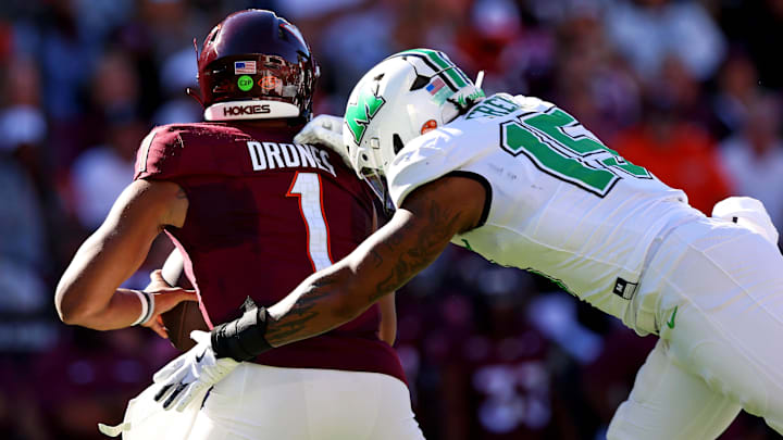 Sep 7, 2024; Blacksburg, Virginia, USA; Marshall Thundering Herd defensive lineman Mike Green (15) sacks Virginia Tech Hokies quarterback Kyron Drones (1) during the first quarter at Lane Stadium. Mandatory Credit: Peter Casey-Imagn Images