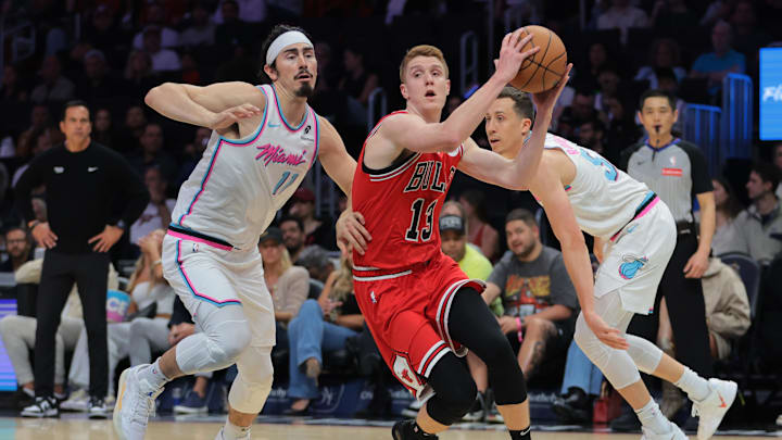 Mar 8, 2025; Miami, Florida, USA; Chicago Bulls guard Kevin Huerter (13) drives to the basket past Miami Heat guard Jaime Jaquez Jr. (11) and forward Duncan Robinson (55) during the first quarter at Kaseya Center. Mandatory Credit: Sam Navarro-Imagn Images