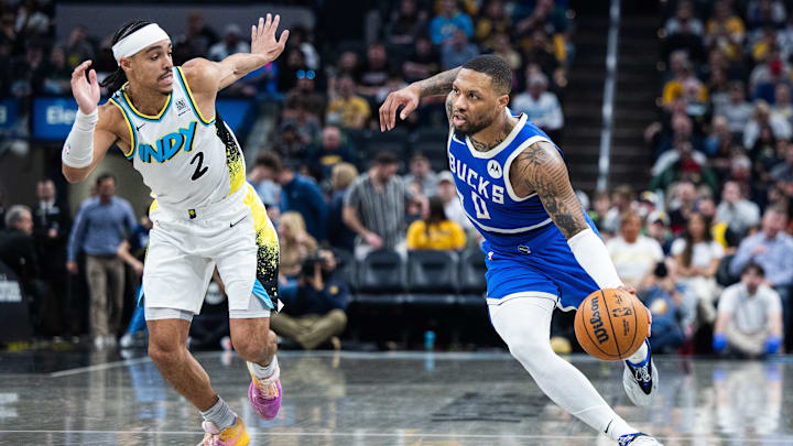 Mar 11, 2025; Indianapolis, Indiana, USA; Milwaukee Bucks guard Damian Lillard (0) dribbles  the ball while Indiana Pacers guard Andrew Nembhard (2) defends in the second half  at Gainbridge Fieldhouse. Mandatory Credit: Trevor Ruszkowski-Imagn Images