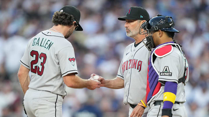 Mar 26, 2026; Los Angeles, California, USA; Arizona Diamondbacks starting pitcher Zac Gallen (23) hands the ball to manager Torey Lovullo (17) during a pitching change as infielder Carlos Santana (41) and catcher Gabriel Moreno (14) look on against the Arizona Diamondbacks during the fifth inning at Dodger Stadium. Mandatory Credit: Kirby Lee-Imagn Images