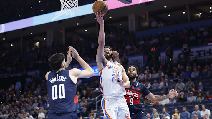 Dec 23, 2024; Oklahoma City, Oklahoma, USA;Oklahoma City Thunder guard Ajay Mitchell (25) shoots between Washington Wizards forward Tristan Vukcevic (00) and forward Justin Champagnie (9) during the second half at Paycom Center. Mandatory Credit: Alonzo Adams-Imagn Images