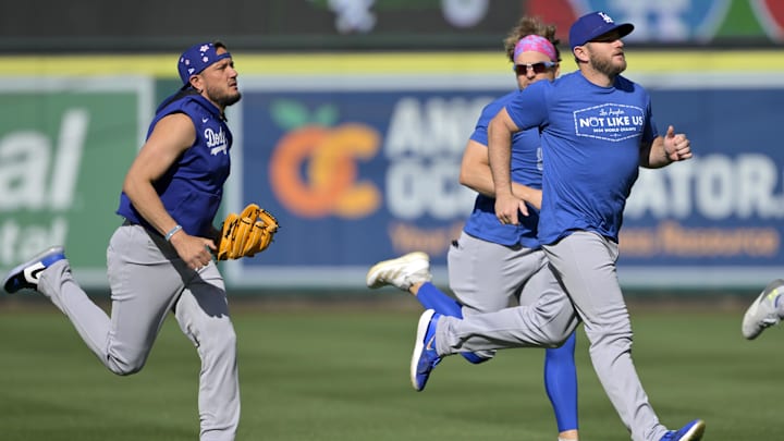 Mar 24, 2025; Anaheim, California, USA;  Los Angeles Dodgers shortstop Miguel Rojas (72), second baseman Enrique Hernandez (8) and third baseman Max Muncy (13) warm up prior to the game against the Los Angeles Angels at Angel Stadium. Mandatory Credit: Jayne Kamin-Oncea-Imagn Images