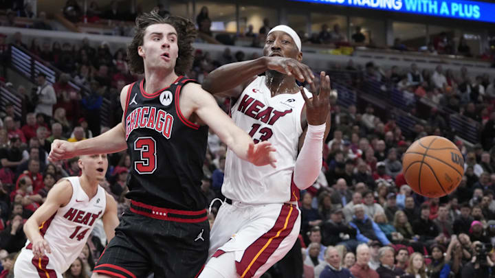 Apr 16, 2025; Chicago, Illinois, USA; Chicago Bulls guard Josh Giddey (3) and Miami Heat center Bam Adebayo (13) go for the ball during the first quarter at United Center. Mandatory Credit: David Banks-Imagn Images