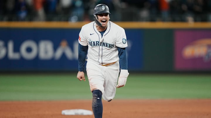 Oct 17, 2025; Seattle, Washington, USA; Seattle Mariners first baseman Josh Naylor (12) reacts after third baseman Eugenio Suarez (not pictured) hits a grand slam against the Toronto Blue Jays in the eighth inning during game five of the ALCS round for the 2025 MLB playoffs at T-Mobile Park. Mandatory Credit: Stephen Brashear-Imagn Images