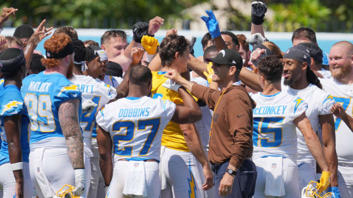 Jun 13, 2024; Costa Mesa, CA, USA; Los Angeles Chargers coach Jim Harbaugh joins hands in a huddle with tight end Donald Parham Jr. (89), running back J.K. Dobbins (27), quarterback Justin Herbert (10) and receiver Ladd McConkey (15) during minicamp at the Hoag Performance Center. Mandatory Credit: Kirby Lee-USA TODAY Sports Jun 13, 2024; Costa Mesa, CA, USA; Los Angeles Chargers coach Jim Harbaugh joins hands in a huddle with tight end Donald Parham Jr. (89), running back J.K. Dobbins (27), quarterback Justin Herbert (10) and receiver Ladd McConkey (15) during minicamp at the Hoag Performance Center. Mandatory Credit: Kirby Lee-USA TODAY Sports