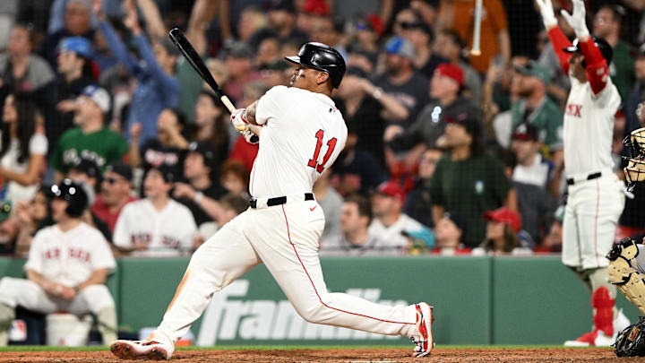 Boston, Massachusetts, USA; Boston Red Sox designated hitter Rafael Devers (11) hits a walk off home run against the Atlanta Braves during the ninth inning at Fenway Park.