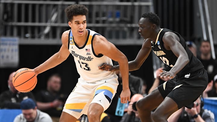 Mar 24, 2024; Indianapolis, IN, USA; Marquette Golden Eagles forward Oso Ighodaro (13) dribbles against Colorado Buffaloes forward Bangot Dak (12) during the first half at Gainbridge FieldHouse. Mandatory Credit: Robert Goddin-USA TODAY Sports