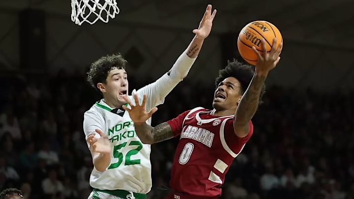 Alabama guard Labaron Philon (0) shoots a layup against North Dakota guard Treysen Eaglestaff (52) at Betty Engelstad Sioux Center in Grand Forks, ND on Wednesday, Dec 18, 2024.