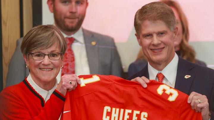 Kansas Gov. Laura Kelly and Kansas City Chiefs CEO Clark Hunt raise a Kansas City Chiefs jersey inside the Robert B. Docking State Office Building on Monday, Dec. 22.