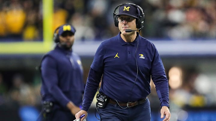 Michigan head coach Jim Harbaugh walks on the field for a timeout against Iowa during the first half