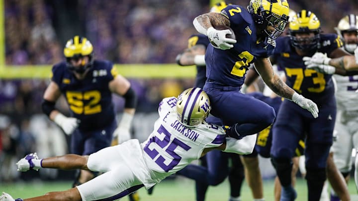 UW cornerback Elijah Jackson (25) brings down Michigan's Blake Corum in the CFP championship game. 