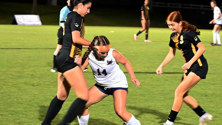 American Heritage senior forward Samantha Villaverde looks to get possession of the ball from Lemon Bay sophomore defender Ella Magri (14) while Julianna Soto (9) enters into the mix during a Class 4A girls soccer state semifinal on Tuesday at Lake Myrtle Sports Complex.