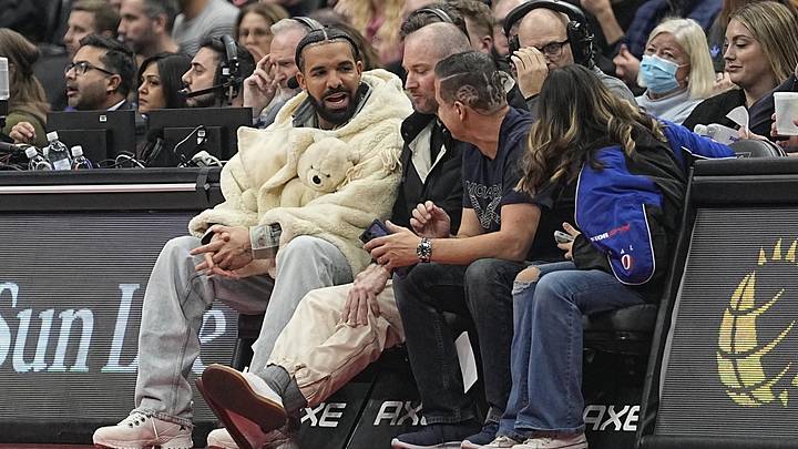 Recording artist Drake (white coat) sits courtside during a game between the Brooklyn Nets and Toronto Raptors at Scotiabank Arena. Recording artist Drake (white coat) sits courtside during a game between the Brooklyn Nets and Toronto Raptors at Scotiabank Arena.