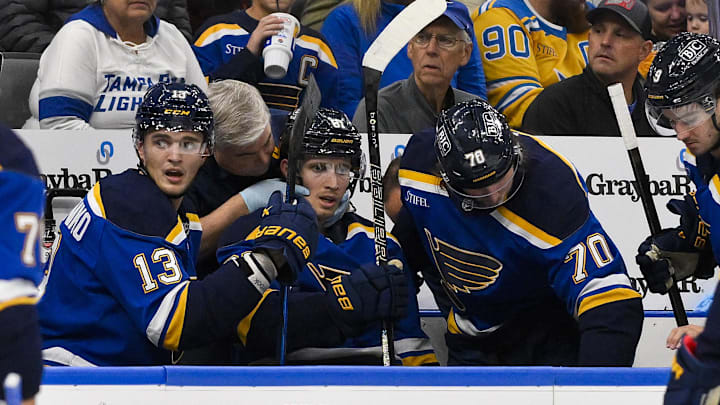 St. Louis Blues center Dylan Holloway is checked on by a trainer after being struck in the throat area by a puck. 