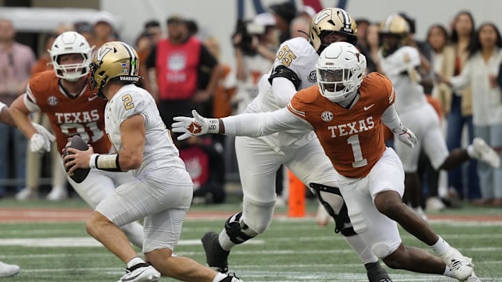 Texas Longhorns defensive lineman Colin Simmons (1) reaches for Vanderbilt Commodores quarterback Diego Pavia (2) during the second half Darrell K Royal-Texas Memorial Stadium. 
