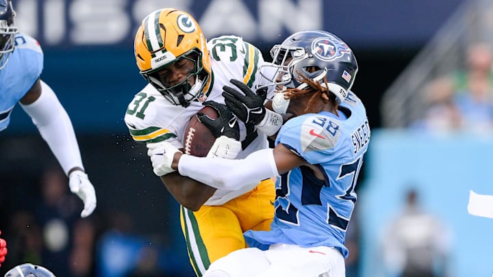 Sep 22, 2024; Nashville, Tennessee, USA;  Tennessee Titans cornerback L'Jarius Sneed (38) tackles Green Bay Packers running back Emanuel Wilson (31) during the first half at Nissan Stadium.