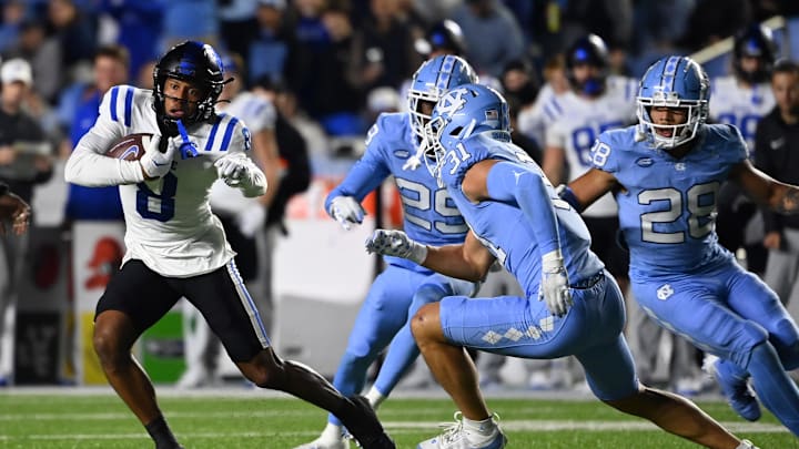 Nov 11, 2023; Chapel Hill, North Carolina, USA; Duke Blue Devils wide receiver Jordan Moore (8) with the ball as North Carolina Tar Heels defensive backs Marcus Allen (29) and  Alijah Huzzie (28) and Will Hardy (31) defend in the second quarter at Kenan Memorial Stadium. Mandatory Credit: Bob Donnan-Imagn Images