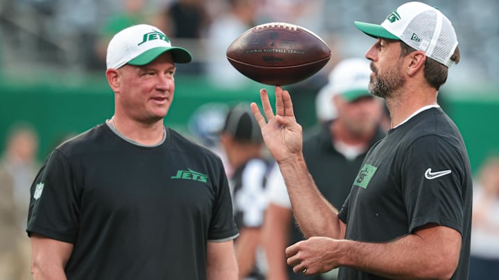 Aug 24, 2024; East Rutherford, New Jersey, USA; New York Jets quarterback Aaron Rodgers (left) spins the ball in front of offensive coordinator Nathaniel Hackett before the game against the New York Giants at MetLife Stadium. Mandatory Credit: Vincent Carchietta-Imagn Images