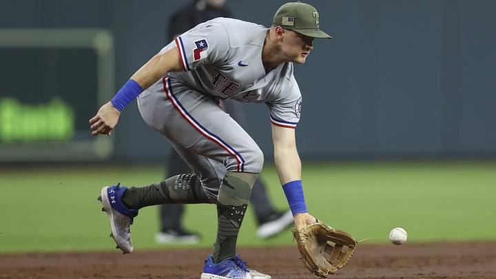 Texas Rangers third baseman Josh Jung fields a ground ball with his glove.
