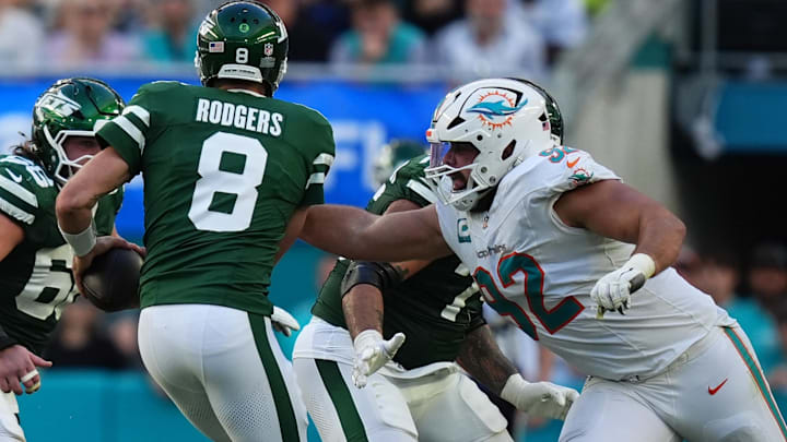 Miami Dolphins defensive tackle Zach Sieler (92) reaches for New York Jets quarterback Aaron Rodgers (8) during the second half at Hard Rock Stadium last December.