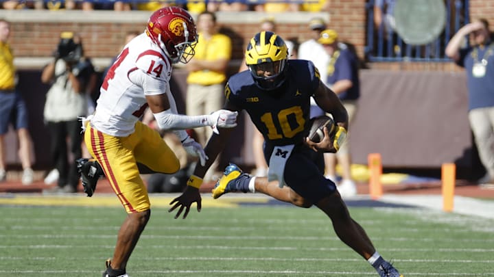 Michigan Wolverines quarterback Alex Orji (10) rushes chased by USC Trojans cornerback Jacobe Covington (14)
