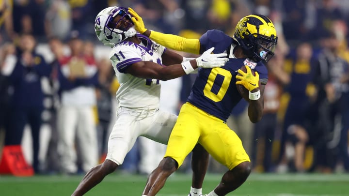 Dec 31, 2022; Glendale, Arizona, USA; Michigan Wolverines defensive back Mike Sainristil (0) stiff arms TCU Horned Frogs wide receiver Derius Davis (11) in the third quarter of the 2022 Fiesta Bowl at State Farm Stadium. Mandatory Credit: Mark J. Rebilas-USA TODAY Sports