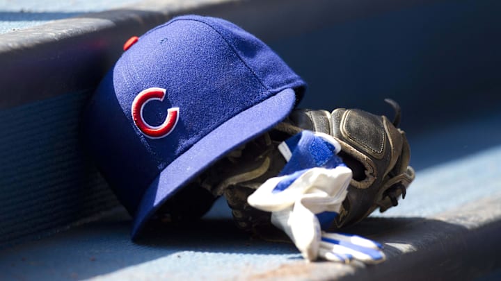 Chicago Cubs hat and glove in the dugout