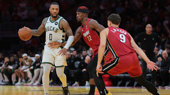 Nov 26, 2024; Miami, Florida, USA; Milwaukee Bucks guard Damian Lillard (0) dribbles the basketball as Miami Heat forward Jimmy Butler (22) and guard Pelle Larsson (9) defend during the third quarter at Kaseya Center. Mandatory Credit: Sam Navarro-Imagn Images Nov 26, 2024; Miami, Florida, USA; Milwaukee Bucks guard Damian Lillard (0) dribbles the basketball as Miami Heat forward Jimmy Butler (22) and guard Pelle Larsson (9) defend during the third quarter at Kaseya Center. Mandatory Credit: Sam Navarro-Imagn Images