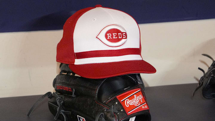 Apr 4, 2025; Milwaukee, Wisconsin, USA; Cincinnati Reds hat and glove rest on the bench in the dugout before a game against the Milwaukee Brewers at American Family Field. Mandatory Credit: Michael McLoone-Imagn Images
