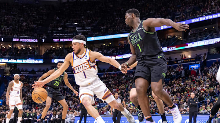 Jan 19, 2024; New Orleans, Louisiana, USA;  Phoenix Suns guard Devin Booker (1) dribbles against New Orleans Pelicans forward Zion Williamson (1) during the first half at Smoothie King Center. Mandatory Credit: Stephen Lew-Imagn Images