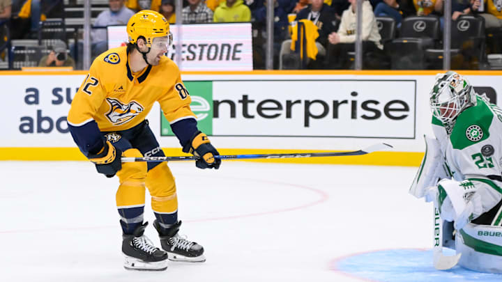 Oct 10, 2024; Nashville, Tennessee, USA; Nashville Predators center Tommy Novak (82) flips the puck past Dallas Stars goaltender Jake Oettinger (29) for a goal during the third period at Bridgestone Arena. Mandatory Credit: Steve Roberts-Imagn Images Oct 10, 2024; Nashville, Tennessee, USA; Nashville Predators center Tommy Novak (82) flips the puck past Dallas Stars goaltender Jake Oettinger (29) for a goal during the third period at Bridgestone Arena. Mandatory Credit: Steve Roberts-Imagn Images