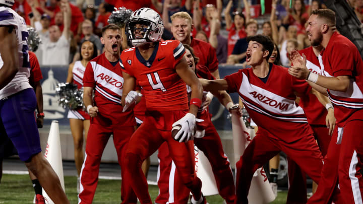Sep 30, 2023; Tucson, Arizona, USA; Arizona Wildcats wide receiver Tetairoa McMillan (4) celebrates a touchdown agaisnt the Washington Huskies with the cheer leaders in the second half at Arizona Stadium. Mandatory Credit: Zachary BonDurant-USA TODAY Sports Sep 30, 2023; Tucson, Arizona, USA; Arizona Wildcats wide receiver Tetairoa McMillan (4) celebrates a touchdown agaisnt the Washington Huskies with the cheer leaders in the second half at Arizona Stadium. Mandatory Credit: Zachary BonDurant-USA TODAY Sports