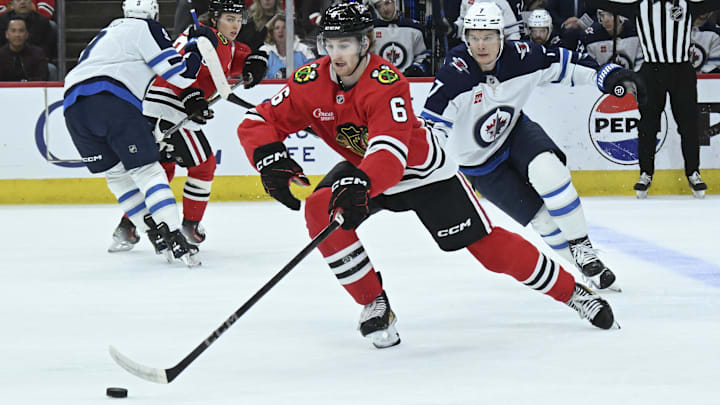 Apr 12, 2025; Chicago, Illinois, USA;  Chicago Blackhawks defenseman Sam Rinzel (6) and Winnipeg Jets center Vladislav Namestnikov (7) chase the puck during the first period at United Center. Mandatory Credit: Matt Marton-Imagn Images