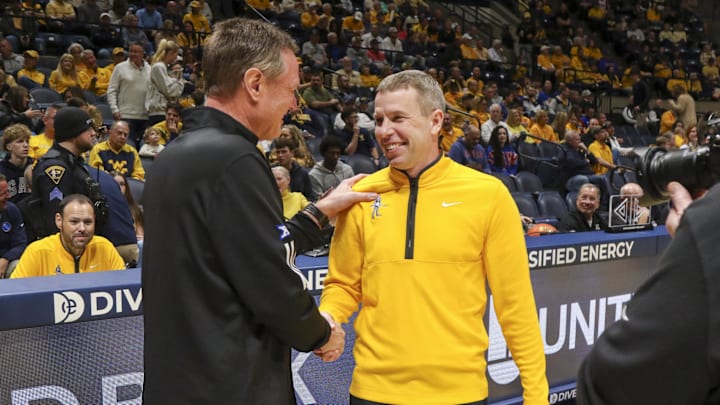 Jan 10, 2026; Morgantown, West Virginia, USA; West Virginia Mountaineers head coach Ross Hodge talks with Kansas Jayhawks head coach Bill Self before the game at Hope Coliseum. Mandatory