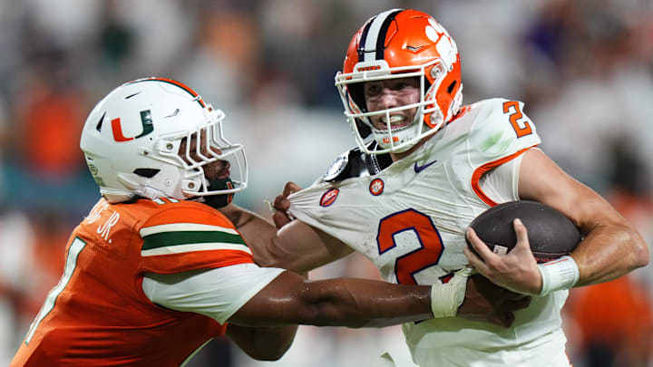 Oct 21, 2023; Miami Gardens, Florida, USA; Miami Hurricanes linebacker Corey Flagg Jr. (11) tackles Clemson Tigers quarterback Cade Klubnik (2) to win the game in over time at Hard Rock Stadium. Mandatory Credit: Rich Storry-Imagn Images