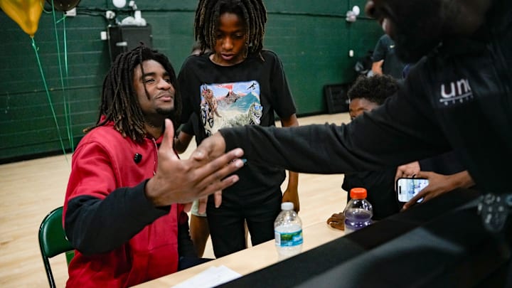 Jayden Petit is greeted by friends and family after signing to play football at the University of Oklahoma during a signing day ceremony at St. John Neumann High School on Naples, Fla., on Wednesday.