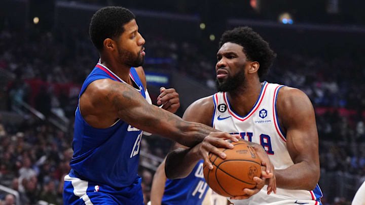 Jan 17, 2023; Los Angeles, California, USA; Philadelphia 76ers center Joel Embiid (21) is fouled by LA Clippers guard Paul George (13) in the first half at Crypto.com Arena. Mandatory Credit: Kirby Lee-Imagn Images