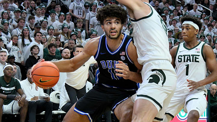 Dec 6, 2025; East Lansing, Michigan, USA;  Duke Blue Devils forward Cameron Boozer (12) advances against Michigan State Spartans center Carson Cooper (15) during the first half at Jack Breslin Student Events Center. Mandatory Credit: Dale Young-Imagn Images