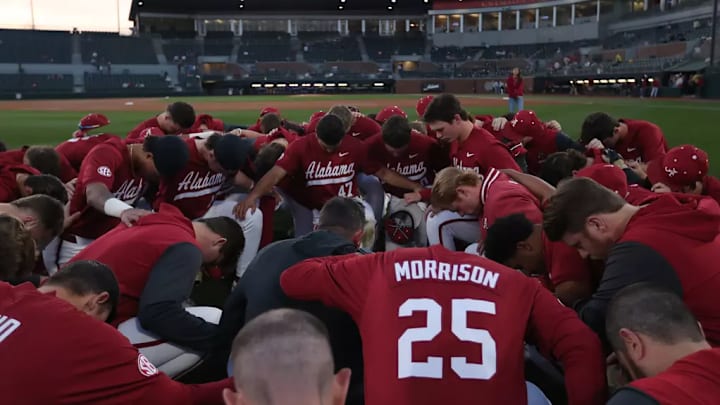 The Alabama baseball team huddles together.