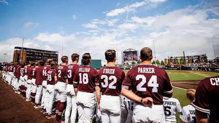 Mississippi State players stand along the third base line during the playing of the national anthem before a game against Kentucky.