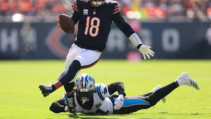 CHICAGO, ILLINOIS - OCTOBER 06: Caleb Williams #18 of the Chicago Bears avoids a tackle from Nick Scott #21 of the Carolina Panthers during the second quarter at Soldier Field on October 06, 2024 in Chicago, Illinois. CHICAGO, ILLINOIS - OCTOBER 06: Caleb Williams #18 of the Chicago Bears avoids a tackle from Nick Scott #21 of the Carolina Panthers during the second quarter at Soldier Field on October 06, 2024 in Chicago, Illinois.