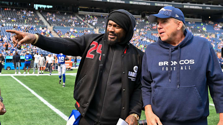 SEATTLE, WASHINGTON - SEPTEMBER 08: Head coach Sean Payton of the Denver Broncos talks with retired NFL player, Marshawn Lynch, before the game against the Seattle Seahawks at Lumen Field on September 08, 2024 in Seattle, Washington. The Seahawks defeated the Broncos 26-20. 