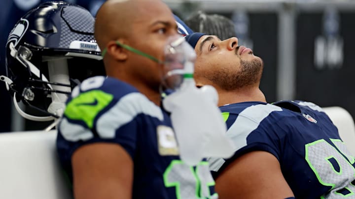 SEATTLE, WASHINGTON - NOVEMBER 12: Tyler Lockett #16 of the Seattle Seahawks and Noah Fant #87 of the Seattle Seahawks react while sitting on the bench during the second quarter against the Washington Commanders at Lumen Field on November 12, 2023 in Seattle, Washington.