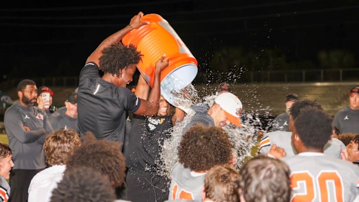 Oviedo High football players give head coach Greg Odierno a Gatorade bath after beating Evans, 29-28, in double overtime to win the Class 6A, District 4 championship. It was the Lions' fourth consecutive district title.