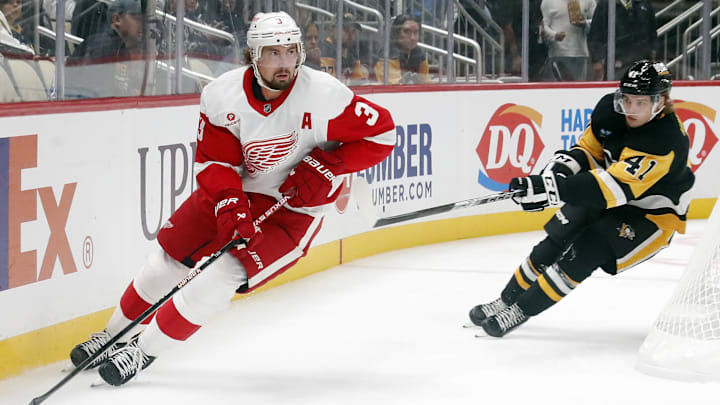 Oct 1, 2024; Pittsburgh, Pennsylvania, USA;  Detroit Red Wings defenseman Justin Holl (3)  skates with the puck as Pittsburgh Penguins right wing Ville Koivunen (41) chases during the first period at PPG Paints Arena. Mandatory Credit: Charles LeClaire-Imagn Images