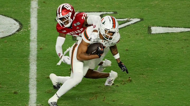 Jan 19, 2026; Miami Gardens, FL, USA; Indiana Hoosiers defensive back Jamari Sharpe (22) tackles Miami Hurricanes wide receiver CJ Daniels (7) in the third quarter during the College Football Playoff National Championship game at Hard Rock Stadium. Mandatory Credit: Kim Klement Neitzel-Imagn Images