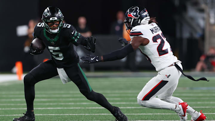 Oct 31, 2024; East Rutherford, New Jersey, USA; New York Jets wide receiver Garrett Wilson (5) runs with the ball against Houston Texans safety Eric Murray (23) during the first half at MetLife Stadium. 