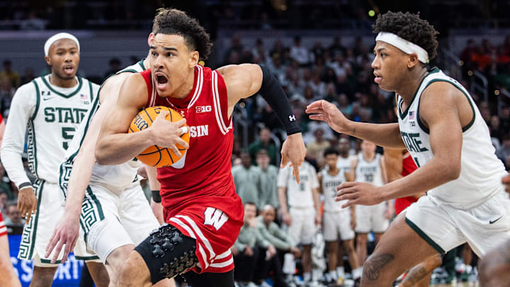 Mar 15, 2025; Indianapolis, IN, USA; Wisconsin Badgers guard John Tonje (9) shoots the ball while Michigan State Spartans guard Jeremy Fears Jr. (1) defends in the second half  at Gainbridge Fieldhouse. Mandatory Credit: Trevor Ruszkowski-Imagn Images